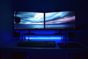 photo: two computer monitors in the dark with blue light